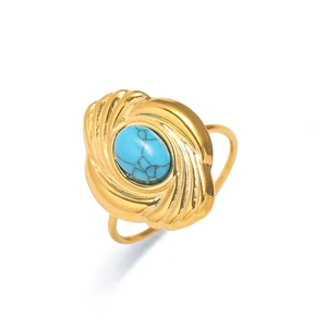 Vista detallada de un anillo vintage dorado con piedra turquesa y bordes de metal