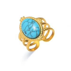 Detalle de anillo dorado vintage con gran turquesa ovalada y banda abierta de 4 niveles