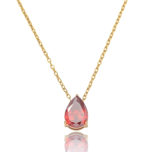 Vue macro du pendentif en pierre rouge poire avec chaîne dorée et reflet miroir élégant
