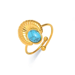 Detalle de anillo dorado ajustable con piedra turquesa ovalada y relieve de concha