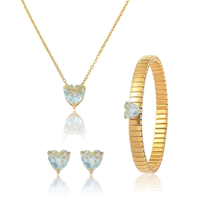 Nahaufnahme von Goldschmuck-Set mit herzförmigen hellblauen Zirkon-Halskette und Ohrringen