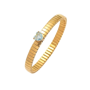 Detailansicht eines goldenen Gliederarmbands mit einem herzförmigen blauen Zirkonstein