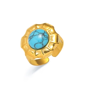 Detalle de un anillo ajustable dorado con una piedra turquesa azul redonda de estilo retro