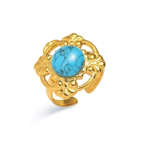 Vista macro de un anillo dorado vintage con piedra turquesa y diseño de encaje hueco