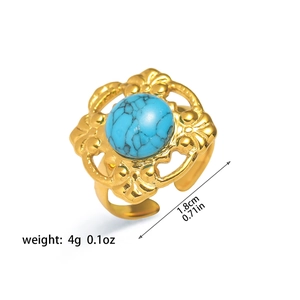 Detalle de anillo vintage dorado con piedra turquesa y grabados florales calados