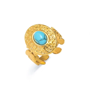 Detalle de anillo vintage dorado con turquesa y diseño de hojas caladas estilo boho