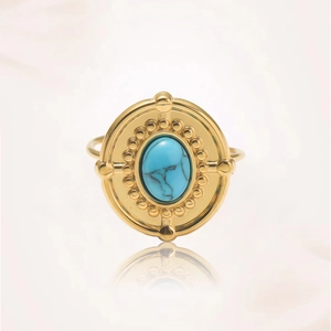 Foto macro de anillo vintage dorado con disco redondo e incrustación de turquesa azul