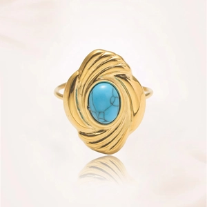 Vista detallada de un anillo dorado vintage con turquesa y textura radial en relieve