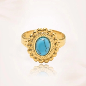 Primer plano detallado de un anillo vintage dorado con piedra turquesa azul y cuentas finas