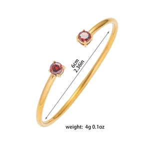 Bracciale aperto dorato con zirconi rossi rotondi e dettagli su dimensioni e peso