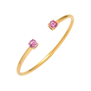 Dettaglio di un bracciale rigido in oro con zirconi rosa rotondi incastonati a griffe