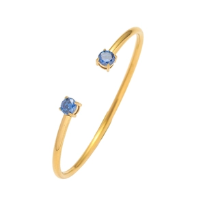 Dettaglio di un bracciale aperto dorato con due zirconi blu tondi con castone a griffe