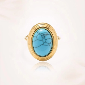 Primer plano de anillo vintage dorado con piedra turquesa ovalada y vetas negras