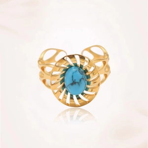 Detalle macro de anillo boho de turquesa con acabado dorado y banda ornamentada
