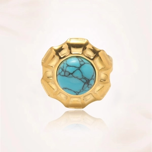 Vista detallada de un anillo de turquesa vintage con engaste dorado y vetas de piedra natural