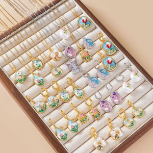 Collection of floral enamel freshwater pearl necklaces and earrings in jewelry display tray