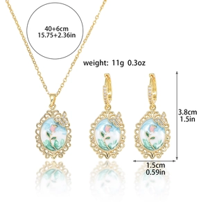 Detail of vintage enamel rose jewelry set with gold-plated filigree and butterfly charms