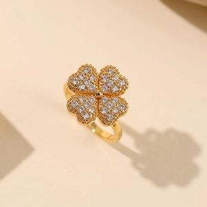 Detailweergave van de draaiende klavervier ring met witte zirkonia stenen in goudkleur
