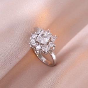 Détail macro d'une bague en argent avec cristal carré et grappe de zircons floraux