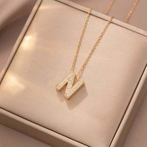 Makroaufnahme der goldenen Buchstabe N Halskette mit Zirkon-Besatz auf einer Schmuckschatulle
