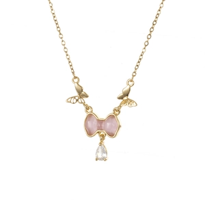 Detail van gouden vlinderketting met roze strik en kristallen druppelhanger
