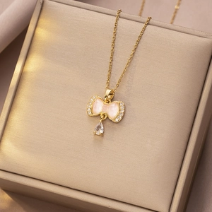 Detail van gouden vlinderketting met roze opaal en waterdruppel zirkonia hanger sieraad