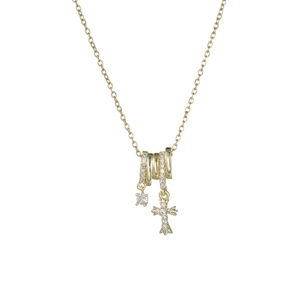 Macro di una collana dorata con anelli di zirconi pavé e un ciondolo a forma di croce