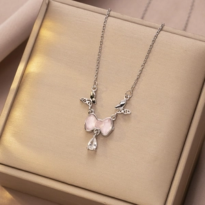 Detail van zilveren ketting met roze strikhanger en bungelende kristallen vlinders