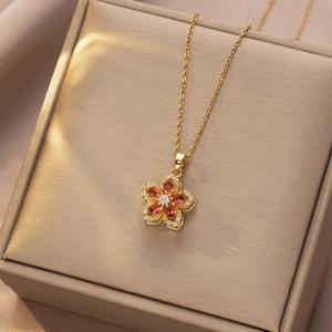 Gedetailleerd aanzicht van draaibare bloemketting met rode edelstenen en gouden laag