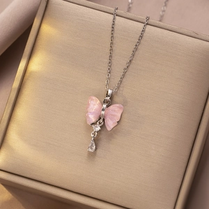 Detail van vlinderketting met roze vleugels en zirkoon hanger aan een zilveren ketting
