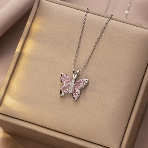 Detail van roze vlinderhanger met peervormige edelstenen en zirkonia op sieraad