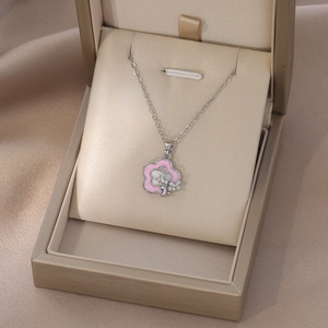 Vue détaillée d'un pendentif fleur en émail rose serti de zircons dans son écrin chic