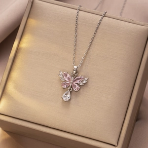 Elegante vlinder hanger ketting met roze stenen en druppel kwastje op een zilveren ketting