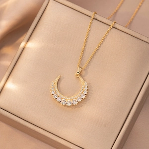 Detailed view of gold moon necklace featuring sparkling white zircons on velvet box