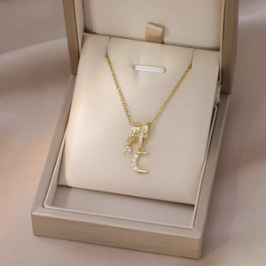 Vista dettagliata di una collana dorata con ciondolo in zircone in una confezione regalo
