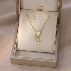 Dettaglio della collana dorata con zirconi su un elegante portagioie in velluto beige