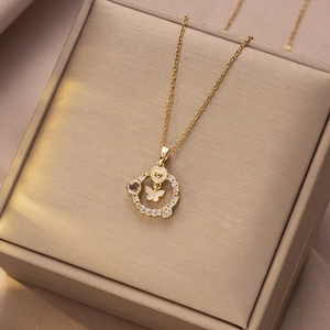 Elegante gouden titanium stalen vlinderketting met zirkoon halo en parelmoer detail