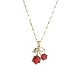 Macro view of gold cherry pendant necklace with red crystals and diamond leaf detail