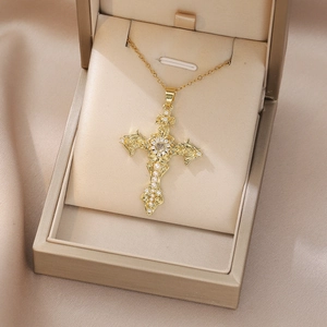 Detailed macro view of vintage gold cross necklace with pearls and zircon in a luxury gift box