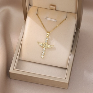 Detail showing Virgin Mary relief on a gold cross necklace with angel wings and zircons