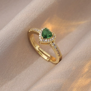Adjustable gold heart ring with green zircon stone and diamonds on champagne silk background