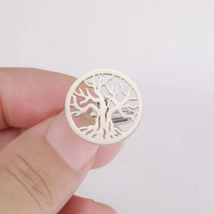 Polished stainless steel round tree of life cufflinks held by hand on white background