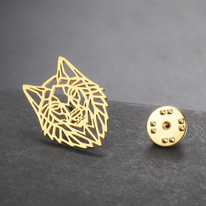 Macro view of gold wolf head brooch with geometric hollow design and butterfly clutch back