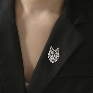 Close-up of geometric wolf head brooch in silver finish pinned on a black suit lapel
