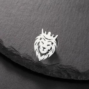 Detailed view of a silver crown lion brooch made of 304 stainless steel on a stone texture