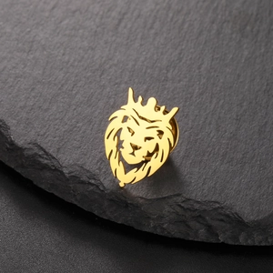Close-up of golden lion head crown lapel pin on a textured dark grey slate stone