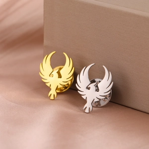 Close-up of gold and silver phoenix lapel pins on a luxury satin gift box