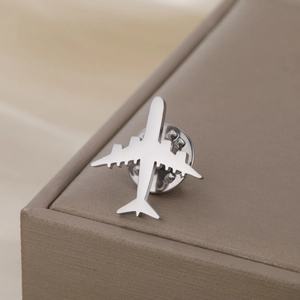 Gros plan détaillé d'une broche avion en argent poli avec fermoir papillon sécurisé