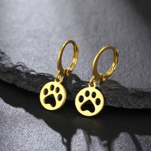 Close-up of golden stainless steel huggie earrings with hollow paw print charms on stone