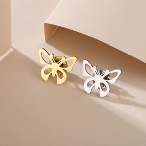 Broches papillon polies en or et argent sur fond géométrique moderne et épuré